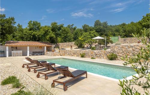 einen Pool mit Liegestühlen neben einer Steinmauer in der Unterkunft Awesome Home In Jadranovo in Jadranovo