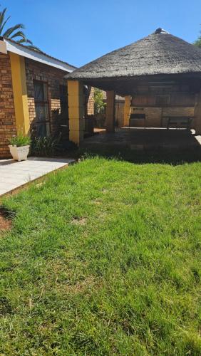 a house with a grass yard in front of it at Goodlife Guest house in mafikeng in Mahikeng