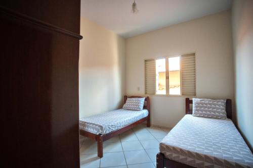 a small room with two beds and a window at Casa em Baependi-Até 7 pessoas in Baependi