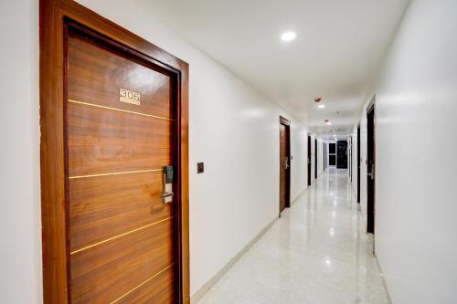 a hallway with a wooden door in a building at Townhouse GRAND ADDRESS HOTEL AND BANQUET in Ghaziabad