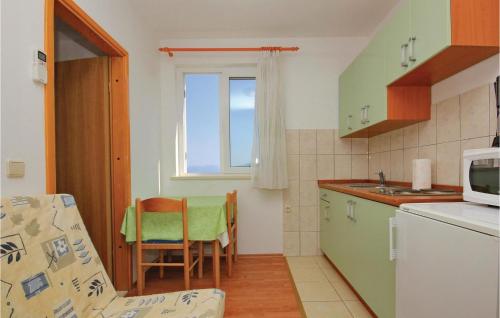 eine kleine Küche mit Tisch und Mikrowelle in der Unterkunft Apartment Prigradica V in Prigradica