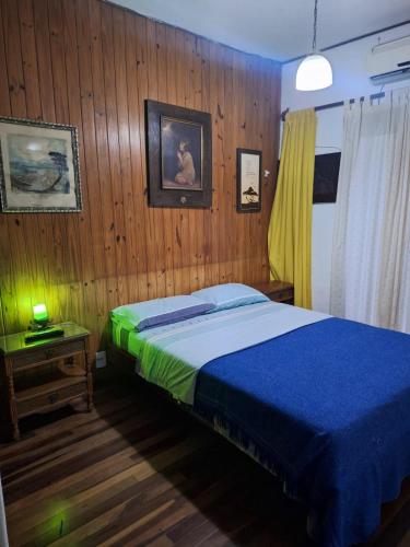 a bedroom with a bed and a wooden wall at Morada urbana pleno centro in Posadas