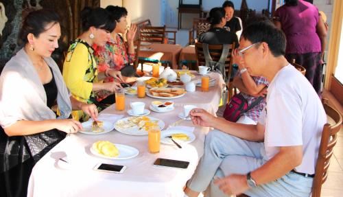 un gruppo di persone sedute attorno a un tavolo che mangiano cibo di Holiday Fashion Inn a Negombo