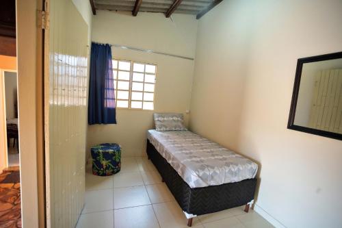 a bedroom with a bed in a room with a window at Casa em Baependi-Até 7 pessoas in Baependi