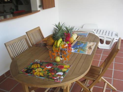 a wooden table with fruit on top of it at LAPALOMADESANSEs2 in Les Anses-dʼArlets