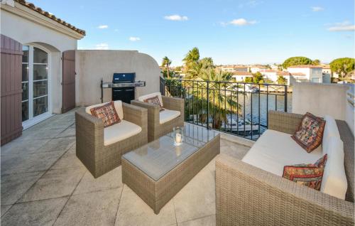 un balcon avec des canapés, une table et un grill dans l'établissement 3 Bedroom Lovely Home In Aigues-Mortes, à Aigues-Mortes