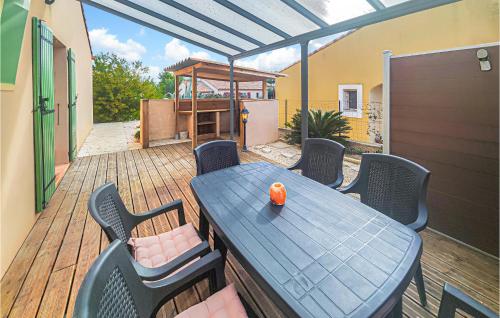 un patio avec une table et des chaises sur une terrasse dans l'établissement Pet Friendly Home In Pouzols-Minervois, à Pouzols-Minervois