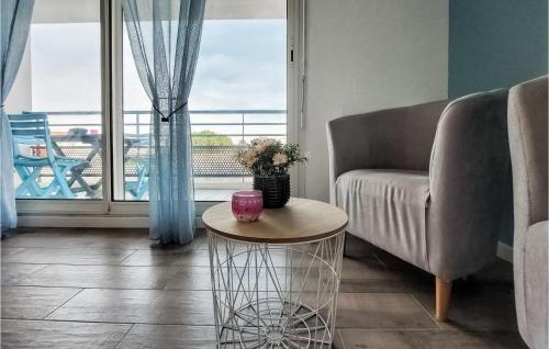 salon z krzesłem, stołem i oknem w obiekcie Awesome Apartment In Royan With Kitchen w mieście Royan