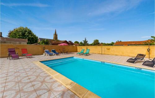 una piscina con sedie a sdraio e sedie accanto a un muro di Awesome Home In St Pierre D'eyraud a Saussignac