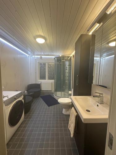 a bathroom with a shower toilet and a sink at Sjöutsikt, Röd trästuga med traditionellt yttre Skandinavisk, modernt inre och alla bekvämligheter, Sol hela dagen på stora altanen, Tryggt, Vinterbonat, Fiske, Båt in Skinnskatteberg