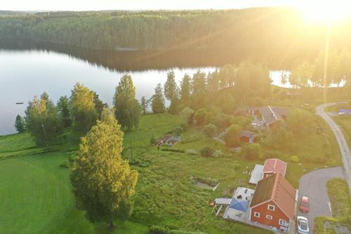 an aerial view of a house next to a lake at Sjöutsikt, Röd trästuga med traditionellt yttre Skandinavisk, modernt inre och alla bekvämligheter, Sol hela dagen på stora altanen, Tryggt, Vinterbonat, Fiske, Båt in Skinnskatteberg