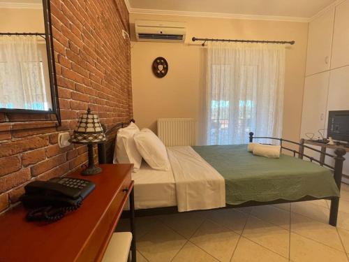 a bedroom with a bed and a brick wall at Althéa in Ambelákion