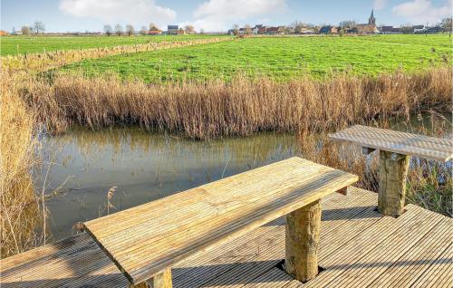 a wooden bench sitting on a boardwalk next to a pond at Awesome Home In Diksmuide With Wifi in Diksmuide