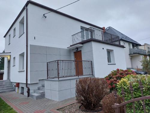 a white house with a balcony on the side of it at Apartament Muszelka in Puck