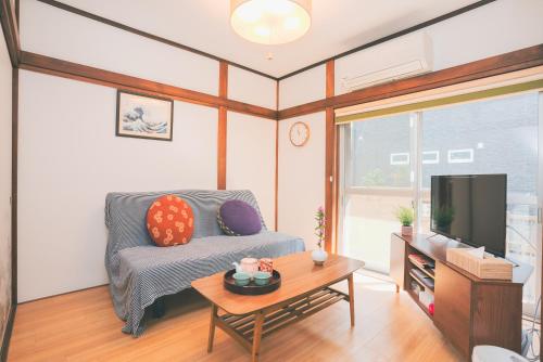 a living room with a couch and a table at -Takaya house- Minamirokugou close Haneda AP in Tokyo