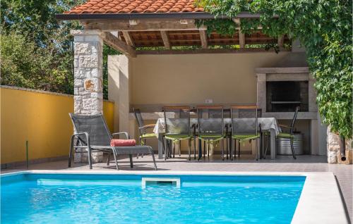 taras ze stołem i krzesłami oraz basenem w obiekcie Four-Bedroom Holiday Home In Perci w mieście Perkovići