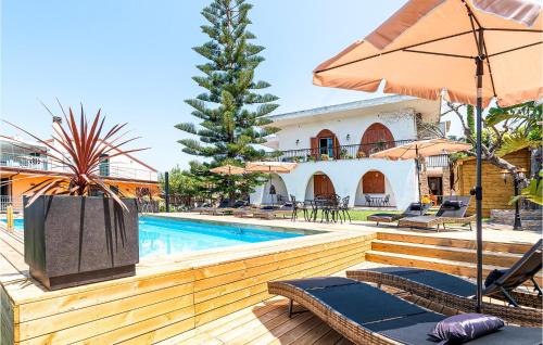 a pool with chairs and umbrellas next to a building at Amazing Apartment In Agropoli With Wifi in Agropoli