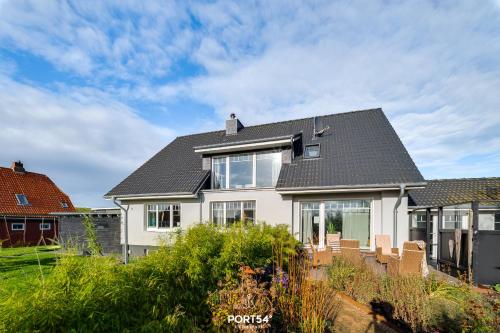 ダゲビュルにあるFerienhaus Pegelbude Dagebüllの灰色の屋根の白い家