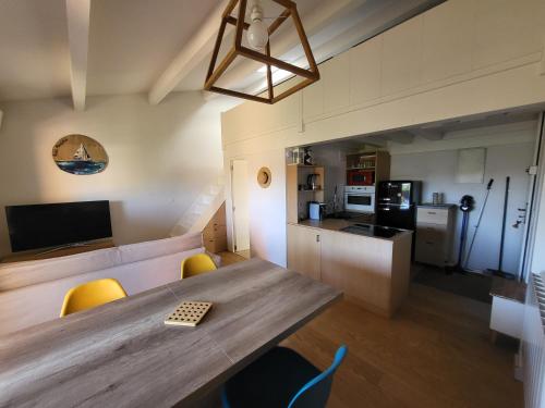 une cuisine et une salle à manger avec une table et des chaises en bois dans l'établissement Appartement Sainte Maxime, à Sainte-Maxime