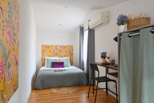 une petite chambre avec un lit et un bureau dans l'établissement L'écrin de Frida - Duplex au cœur de la ville, à Nîmes