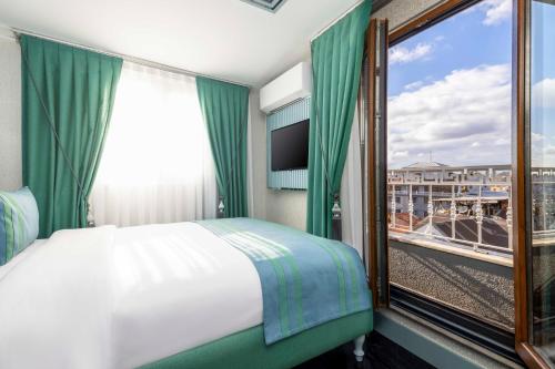 a bedroom with a bed and a window with a view at Santa Rio Gold Taxim Hotel in Istanbul