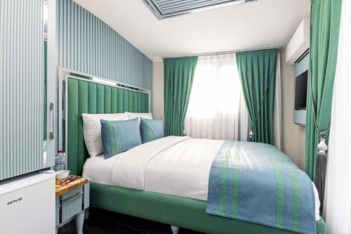 a bedroom with a bed with green walls and a window at Santa Rio Gold Taxim Hotel in Istanbul