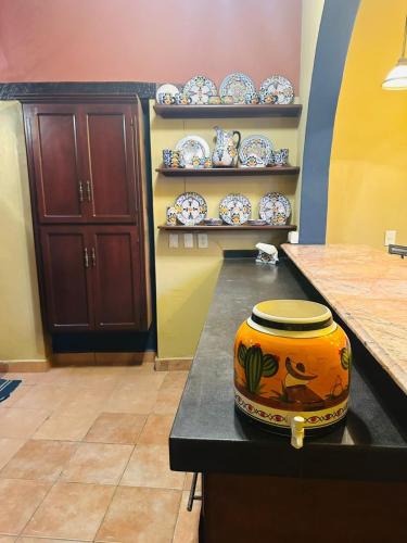 a vase sitting on a counter in a room with plates at Casa de Leyendas in Mazatlán