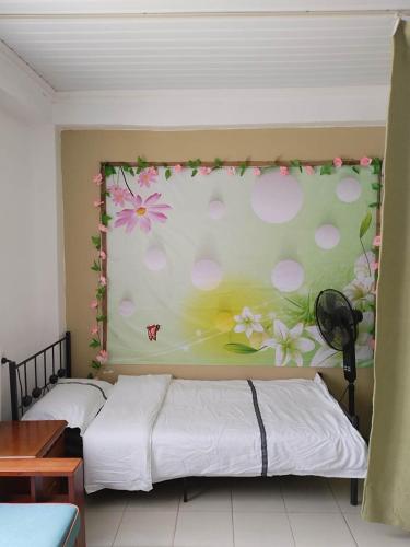 two beds in a room with flowers on the wall at Nadi Airport rooms in Nadi