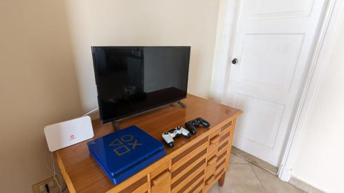 a tv on a wooden dresser with two video game controllers at Golf Heights Resort - Sea and Mountain View - Free WIFI - Sharm El Sheikh in Sharm El Sheikh