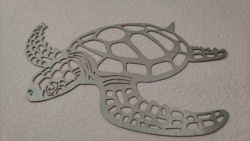a metal drawing of a turtle on a wall at Casa Luna y Sol in Puerto del Rosario
