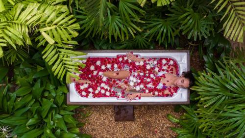 an overhead view of two people in a pool with red sprinkles at Aditya Resort in Hikkaduwa