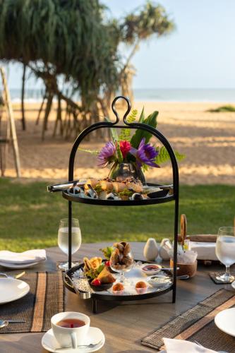 a table with a plate of food on a stand at Aditya Resort in Hikkaduwa
