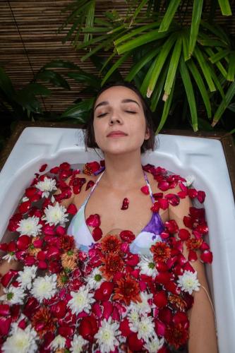 a woman laying in a bath tub filled with flowers at Aditya Resort in Hikkaduwa