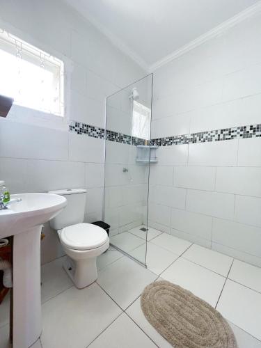 a white bathroom with a toilet and a sink at Belo Espaço in Indaiatuba
