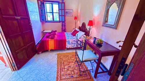 a bedroom with a bed and a desk and a desk at Dar Nakhla - Zagora guest house in Zagora