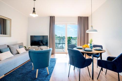 salon z kanapą, stołem i krzesłami w obiekcie Perfect View - najlepszy widok w Iławie plus garaż podziemny, winda, Netflix w Iławie