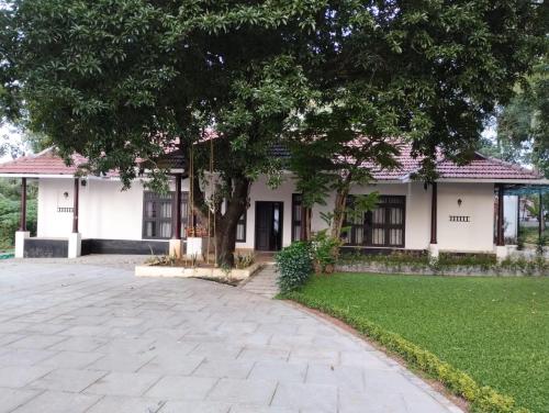 a house with a tree in front of it at Traditional Kerala Home in Kollam