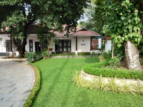 a house with a lawn in front of it at Traditional Kerala Home in Kollam