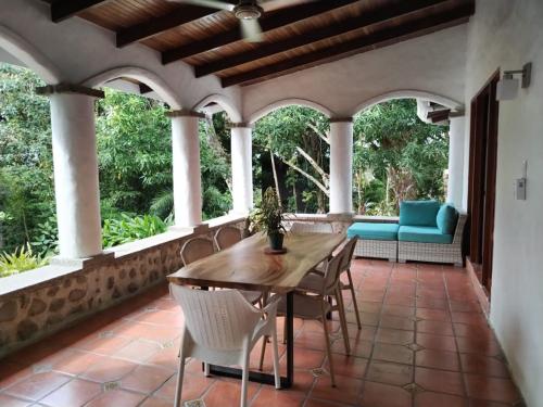 an outdoor patio with a wooden table and chairs at Hotel Planeta Sano in Manuel Antonio