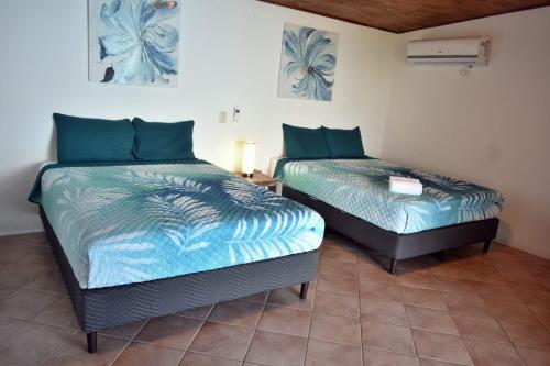 two beds sitting next to each other in a room at Hotel Planeta Sano in Manuel Antonio