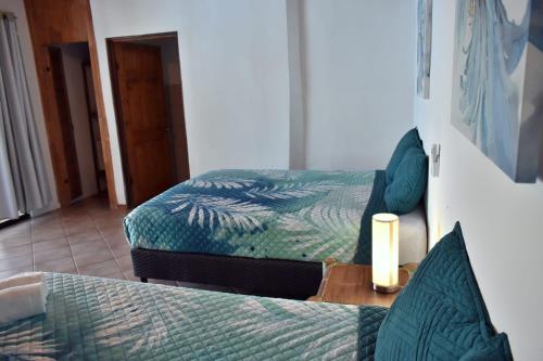 a bedroom with two beds and a candle on a table at Hotel Planeta Sano in Manuel Antonio