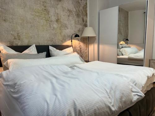 a large white bed in a bedroom with a mirror at Dortmunder Stadtoase in Dortmund