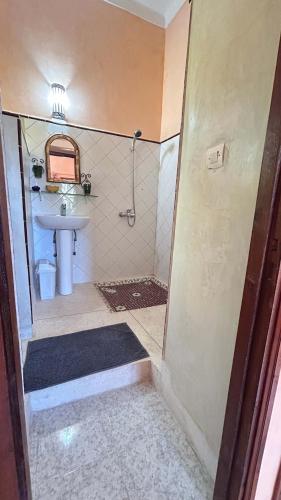 a small bathroom with a sink and a shower at Dar Nakhla - Zagora guest house in Zagora