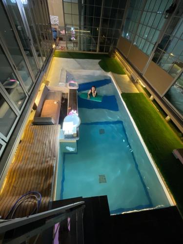 a person in a swimming pool in a building at Aiko poolvilla in Lampang