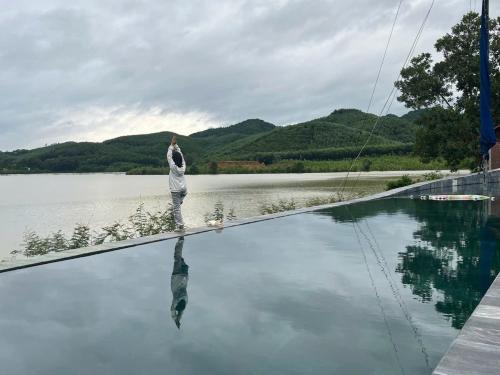 a woman standing on the edge of a body of water at Nguyen Shack Retreat Resort in Phong Nha