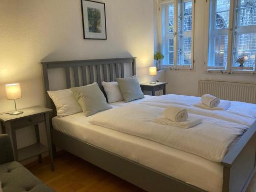 Un dormitorio con una gran cama blanca con dos almohadas. en Anno 1577 - Marktkirchhof 6, en Quedlinburg