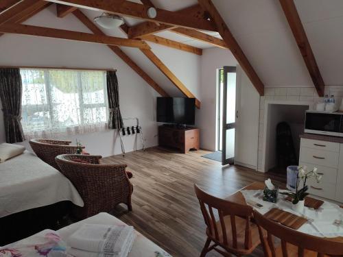 a room with a bed and a table and a tv at Whitianga Luxurious studio room in Whitianga