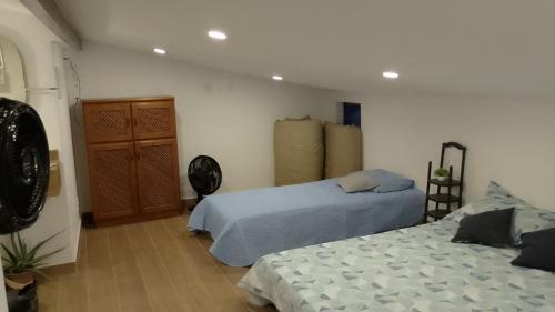 a bedroom with two beds and a dresser at Casa Duplex Condomínio Ipanema no Peró in Cabo Frio