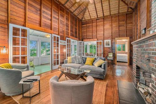 a living room with a couch and chairs and a fireplace at Birch Tree Landing on Hamlin Lake in Ludington