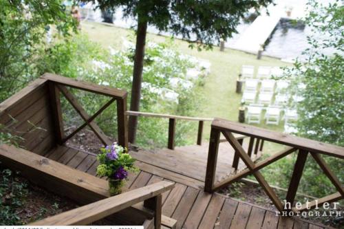 a wooden deck with a bench and flowers on it at Birch Tree Landing on Hamlin Lake in Ludington